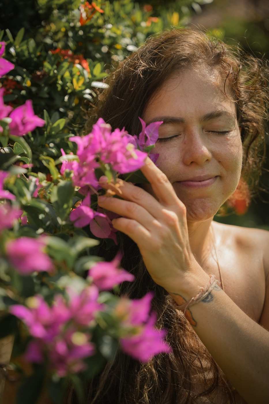 Kali with her eyes closed among pink bougainvillea flowers